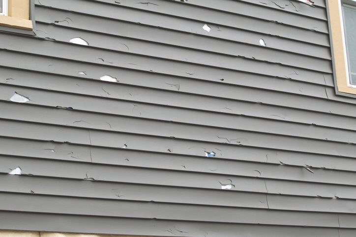 How Professional Siding Replacement Can Transform Your Home’s Curb Appeal 1 Close-up image of cracked, faded, or warped siding panels before replacement